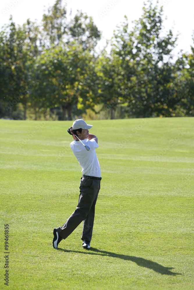 Young Man Taking a Golf Swing