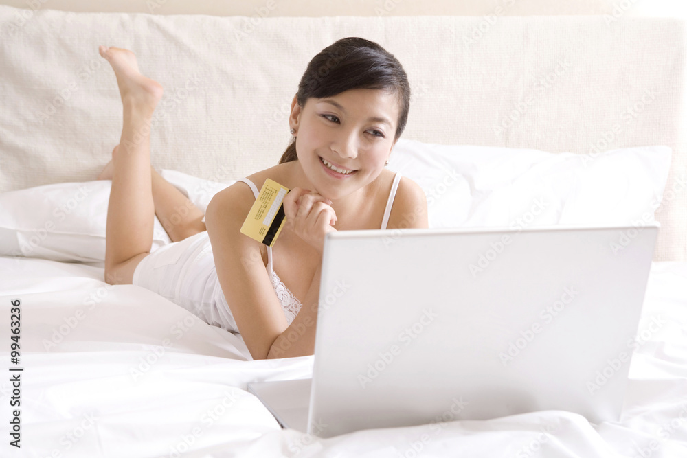 Asian woman on bed with a laptop