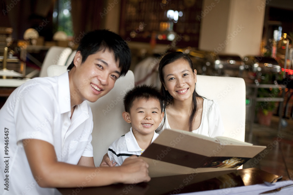 Portrait of a happy family looking through a menu