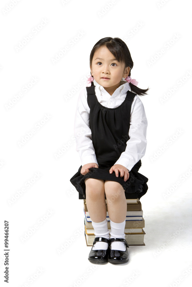 小女孩坐在一堆书上