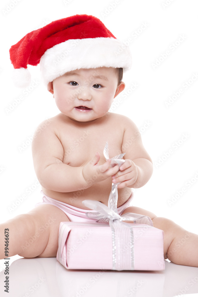 戴圣诞帽带礼盒的女婴