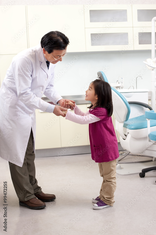 Dentist shaking hands with a little patient