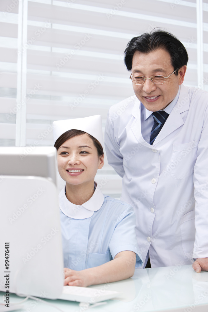 Doctor and nurse using computer in hospital