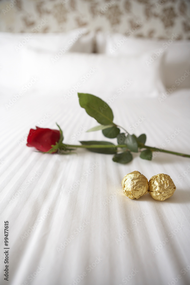 白床上的玫瑰和巧克力