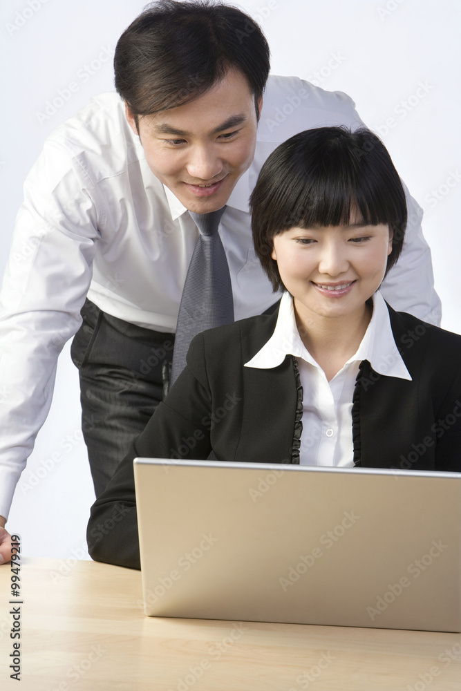 商人和女商人看着笔记本电脑