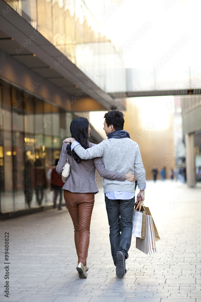 年轻夫妇在城市街道购物