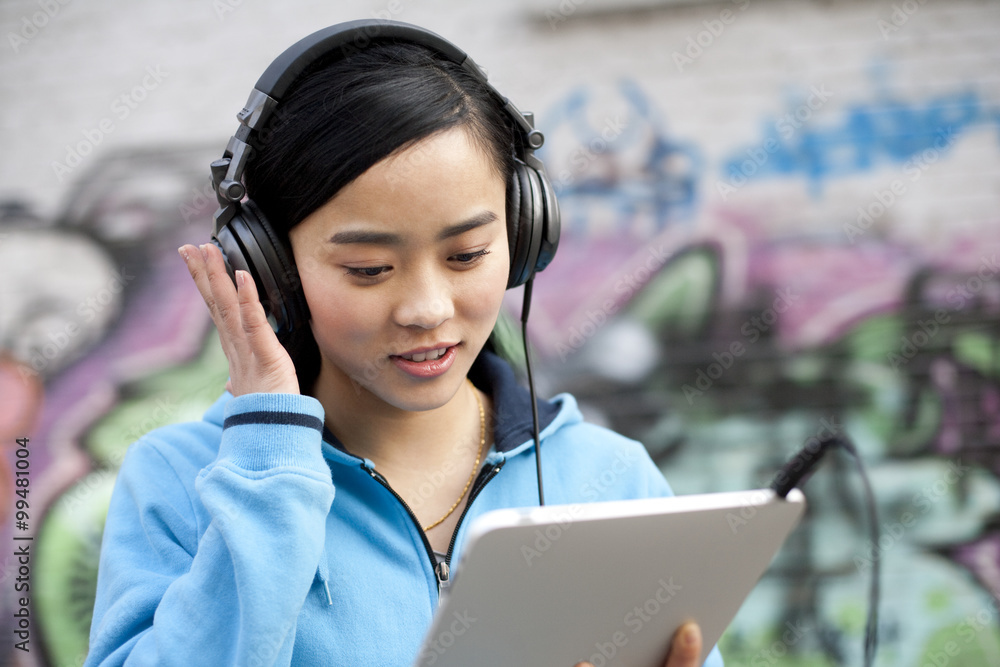 Woman Using an Ipad and Listening to Music