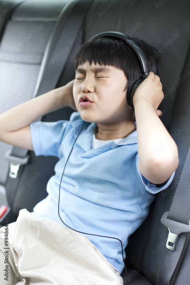 可爱的男孩在车里听音乐唱歌