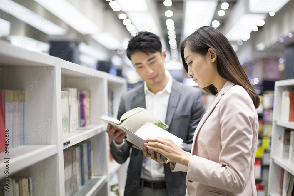 Young couple choosing books in bookstore