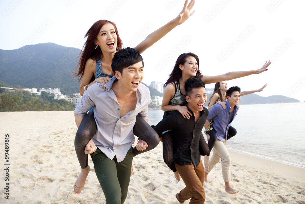 兴奋的年轻人在香港浅水湾海滩背驮