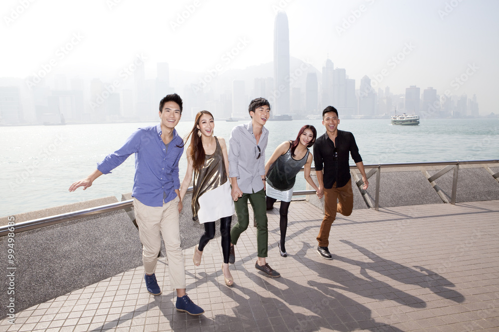 开心的年轻朋友欣赏香港维多利亚港的壮观景色