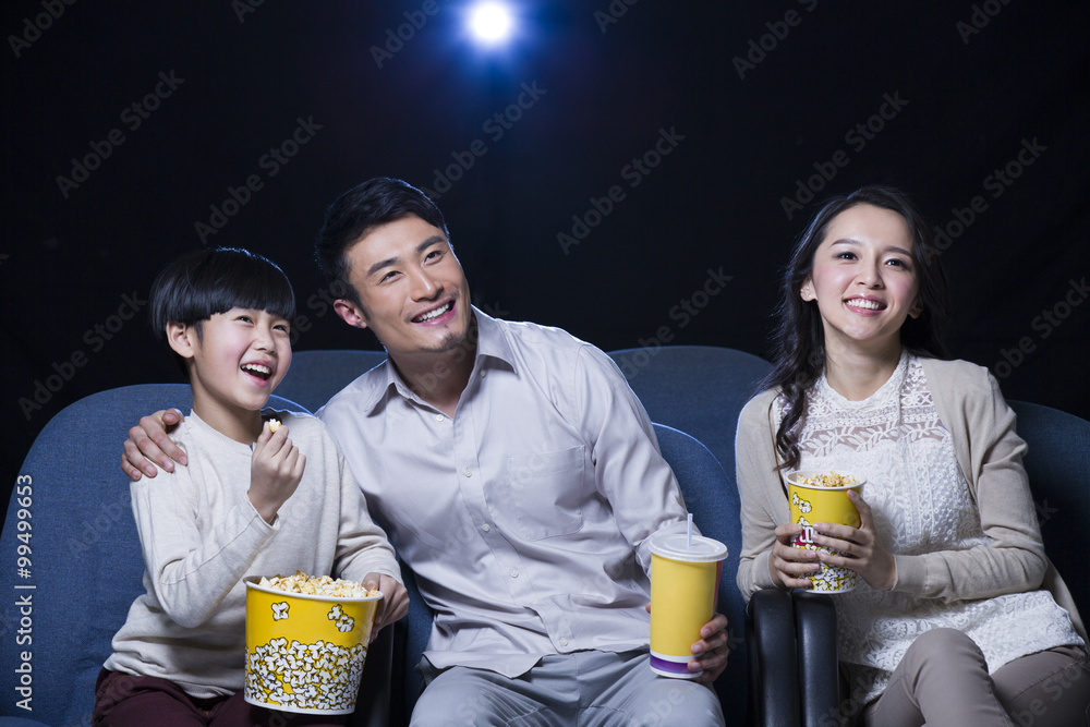 年轻的一家人在电影院看电影
