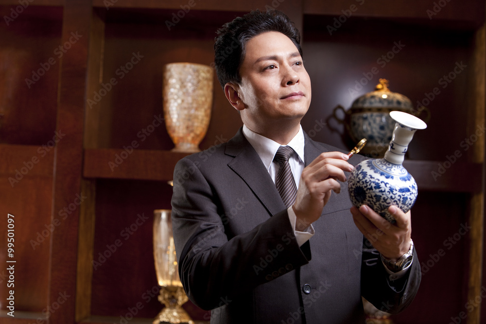 Mature businessman admiring an antique Chinese vase