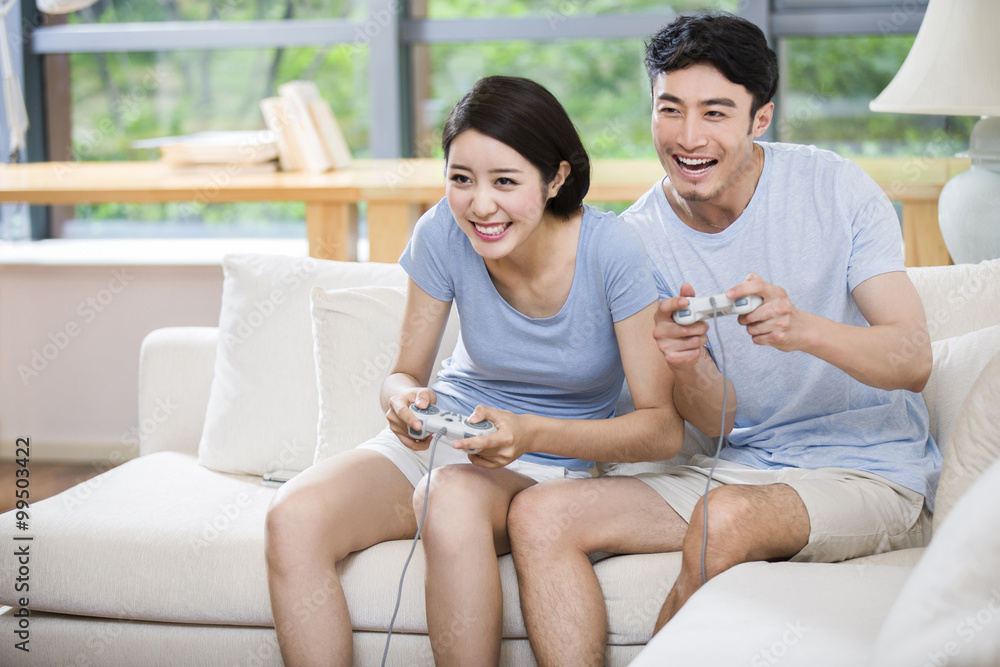 年轻情侣一起玩电子游戏