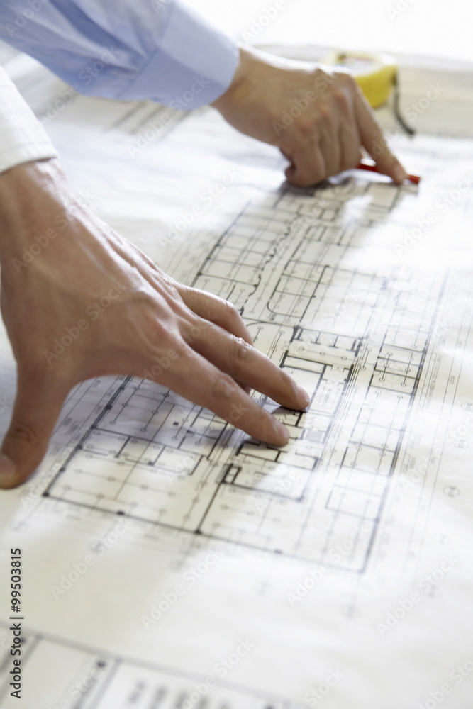 Architects Pointing At Building Plans