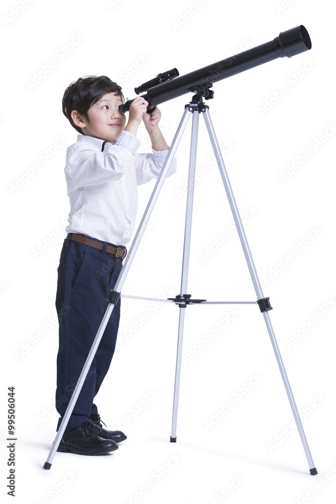 Cute boy looking through an astronomical telescope
