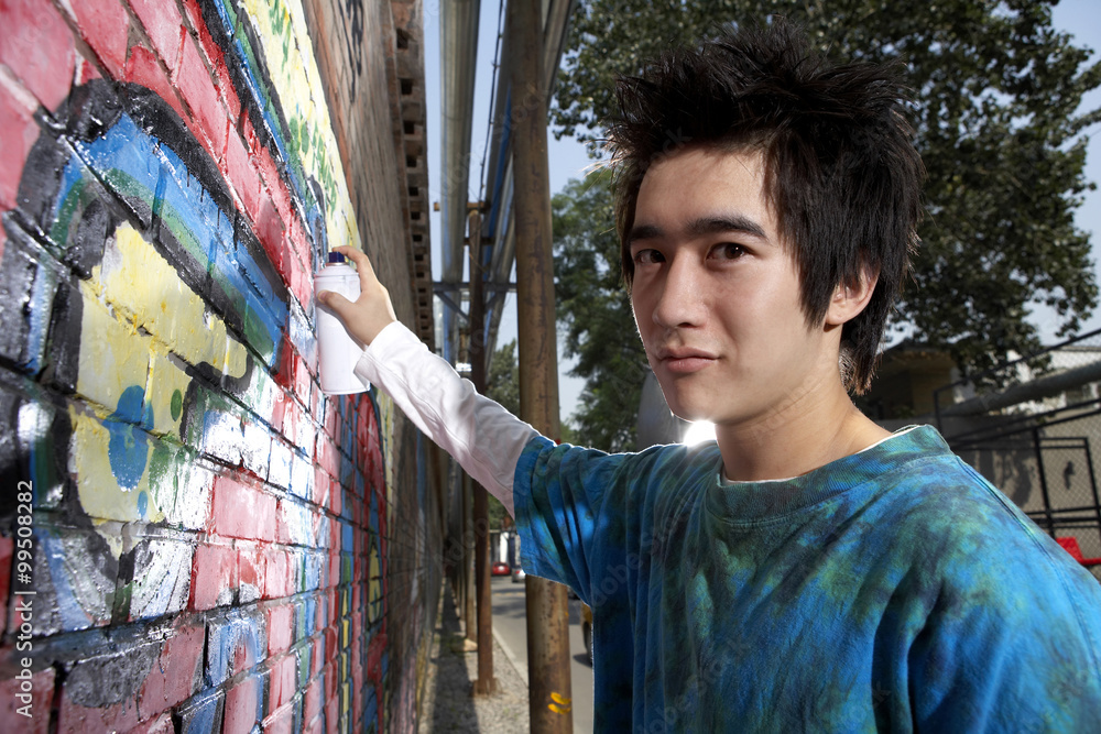 十几岁的男孩在墙上喷涂鸦