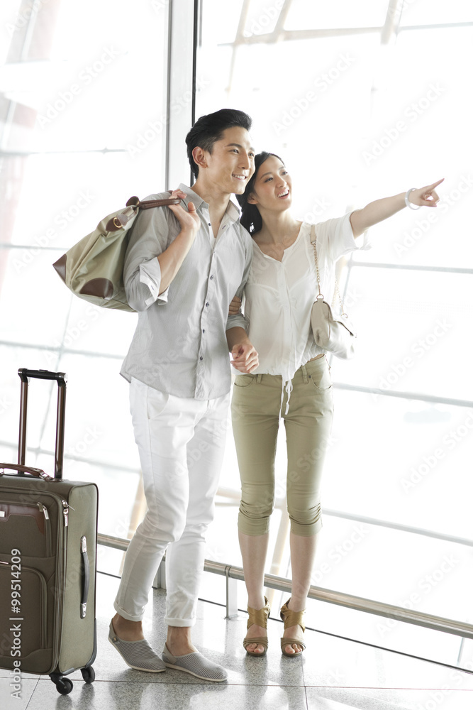 在机场看风景的年轻夫妇