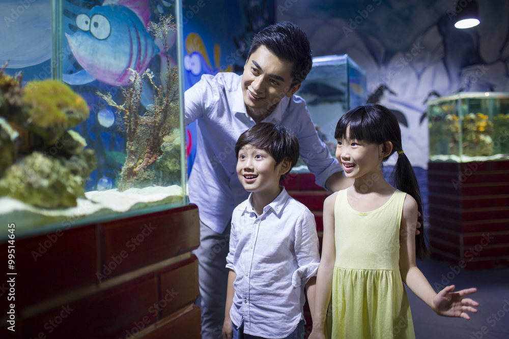 Young father and children in aquarium
