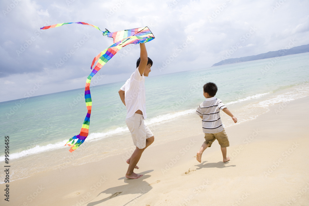父亲和儿子在海滩放风筝