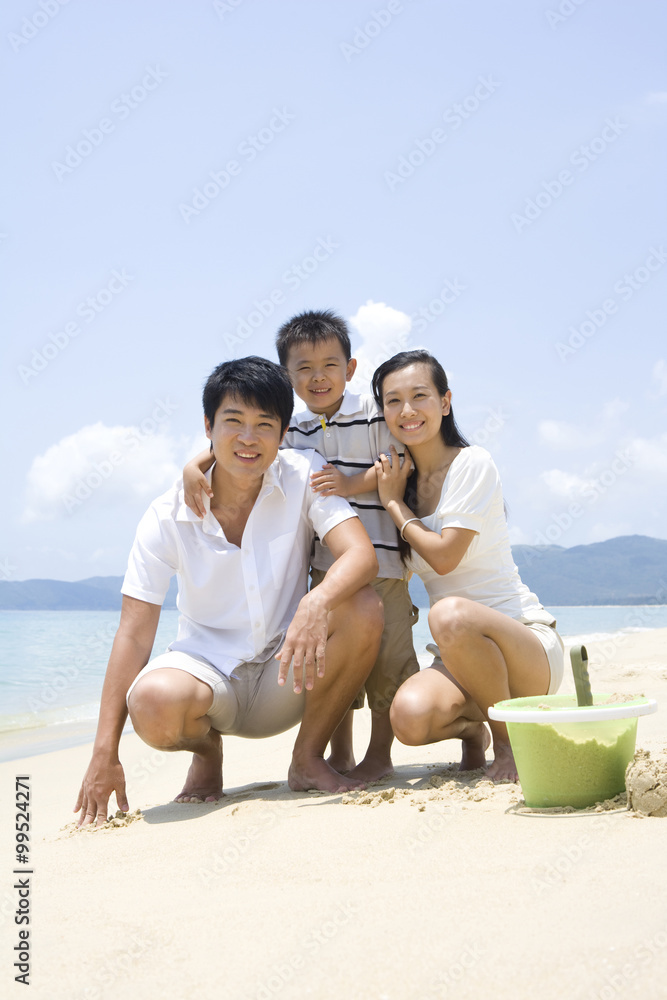 年轻的一家人在海滩上玩耍