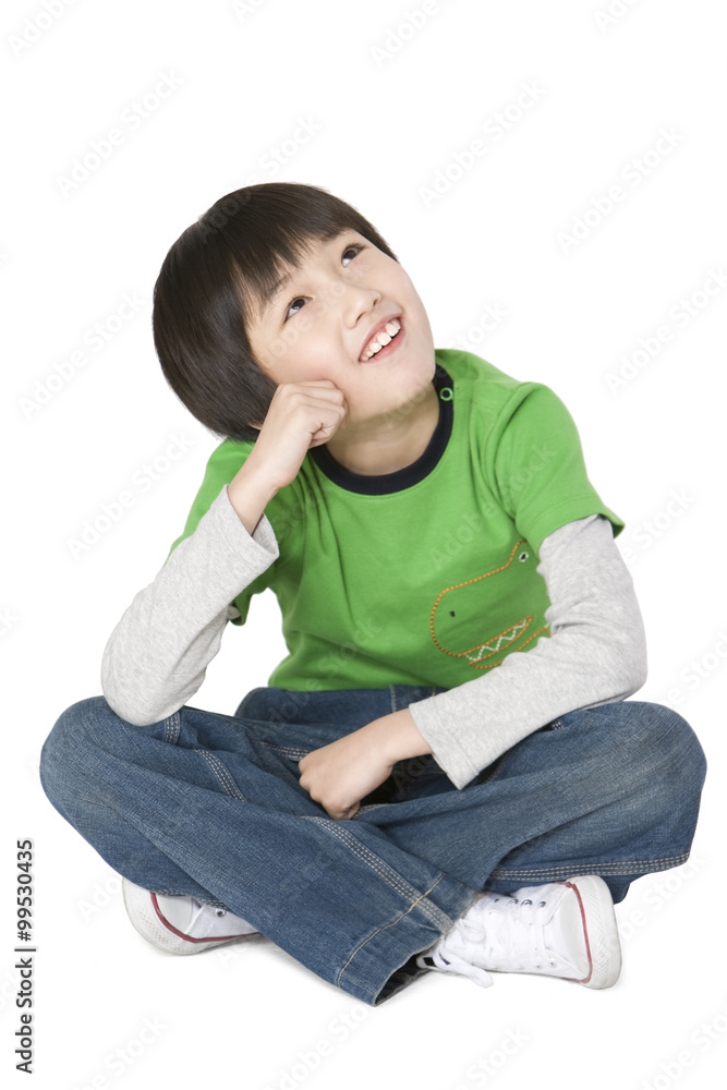 Young boy sitting and looking up thinking