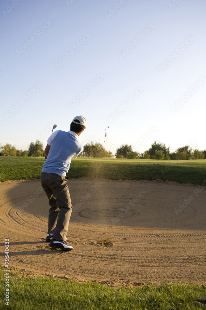 高尔夫球手在沙坑中摇摆