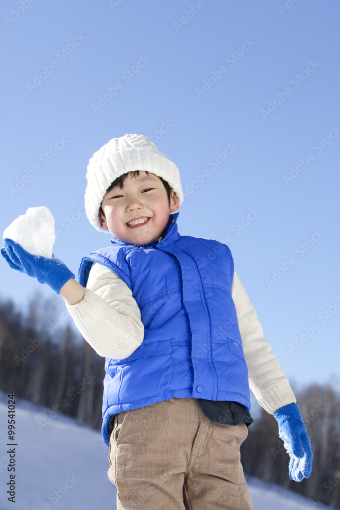 小男孩在雪地里玩得很开心