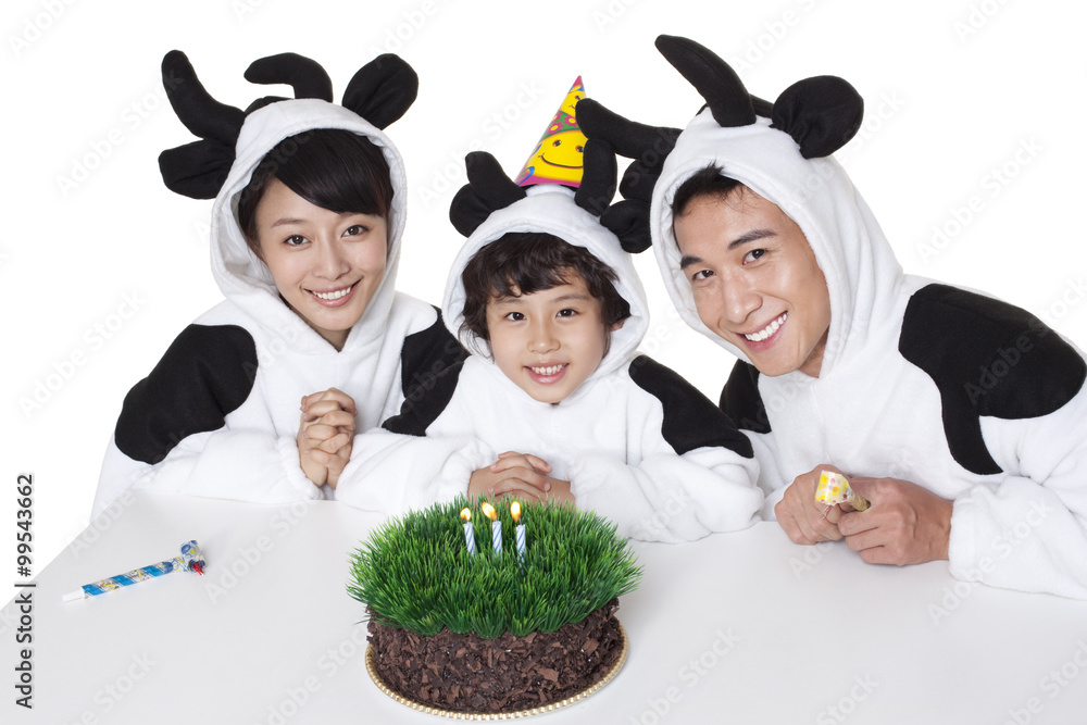 一家人穿着奶牛服装，吃着草生日蛋糕