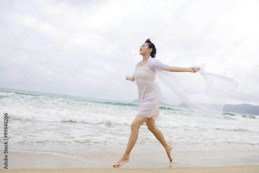 一位年轻女子在海滩上奔跑的肖像
