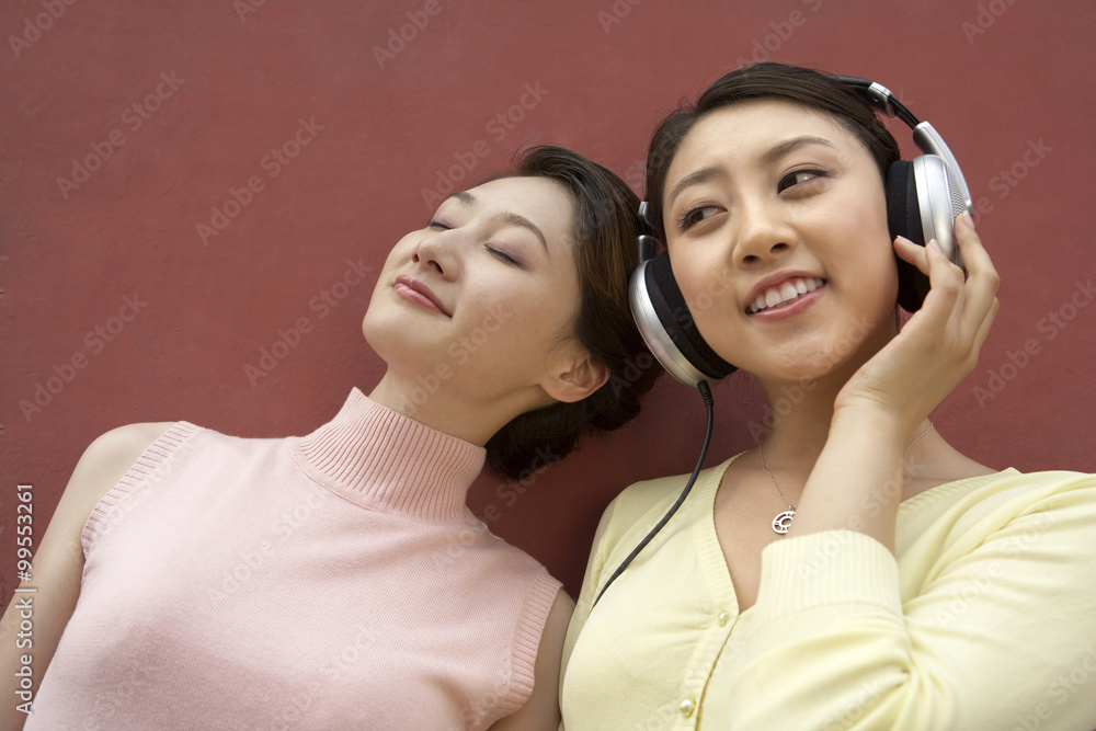 两个年轻的女人在听音乐
