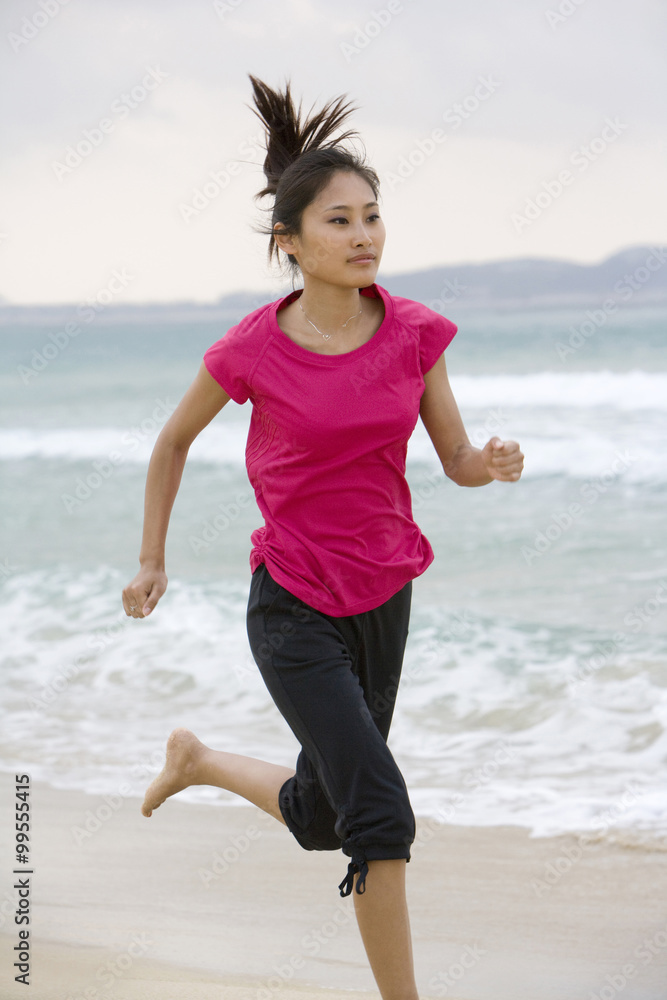 年轻女子在海滩上奔跑