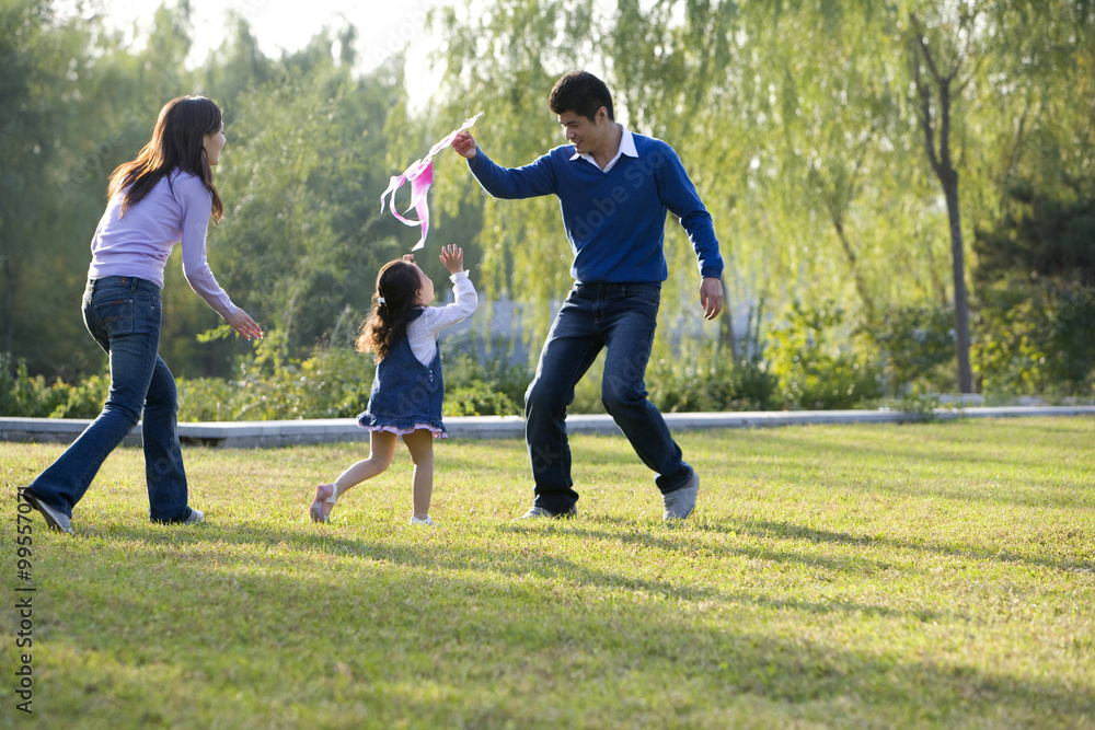 年轻的一家人在公园里放风筝