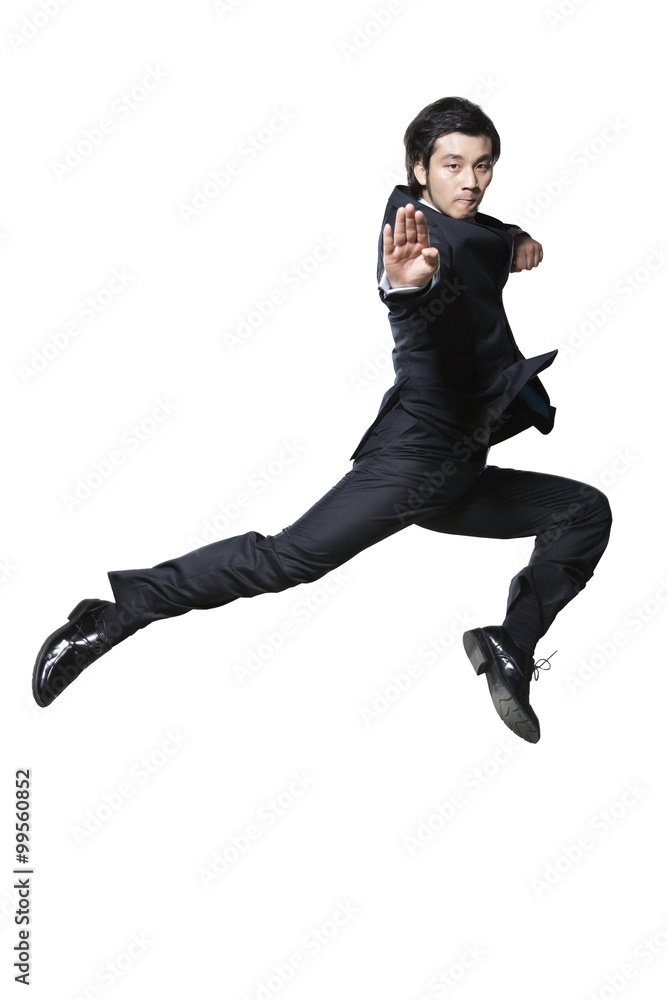 Businessman in martial arts pose mid-air