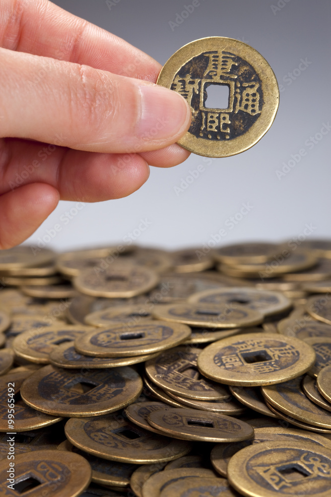 将中国传统硬币放在一堆硬币上