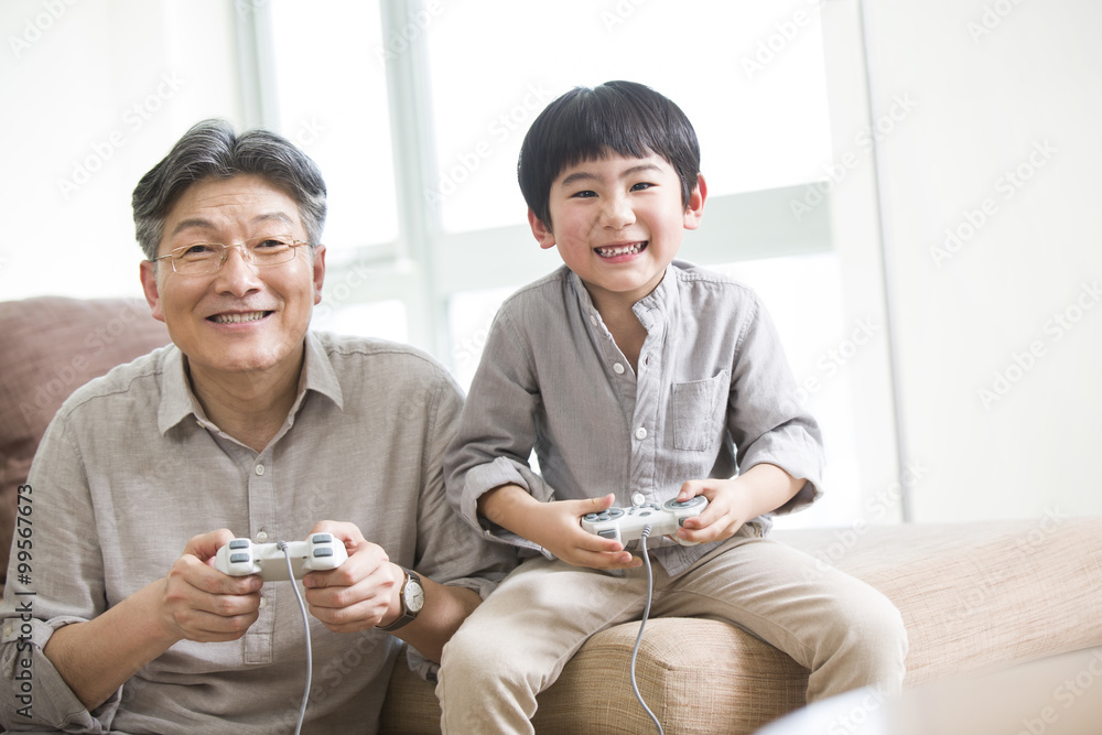 愉快的爷爷和孙子玩电子游戏