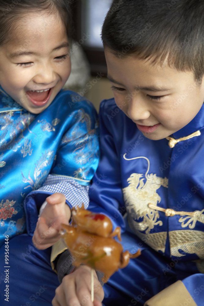 Traditionally Dressed Children Playing With Figurine