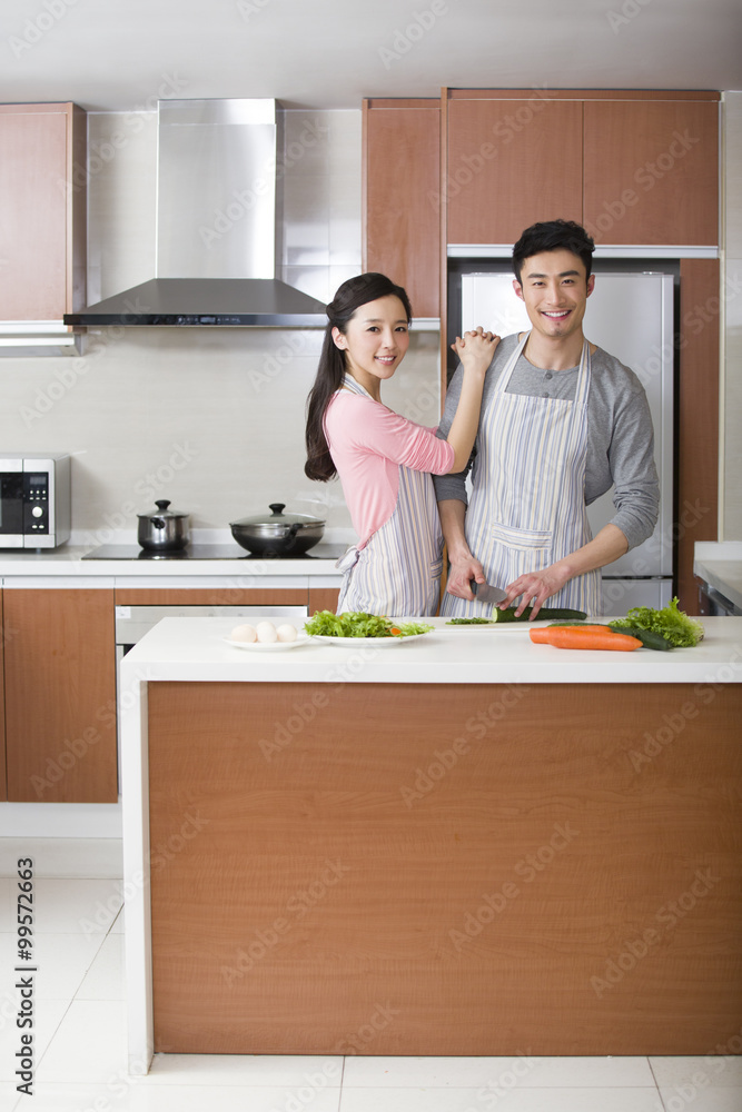 快乐的年轻夫妇正在准备饭菜