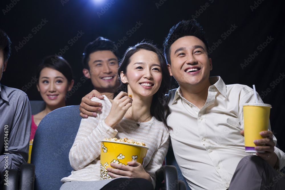 年轻情侣在电影院看电影