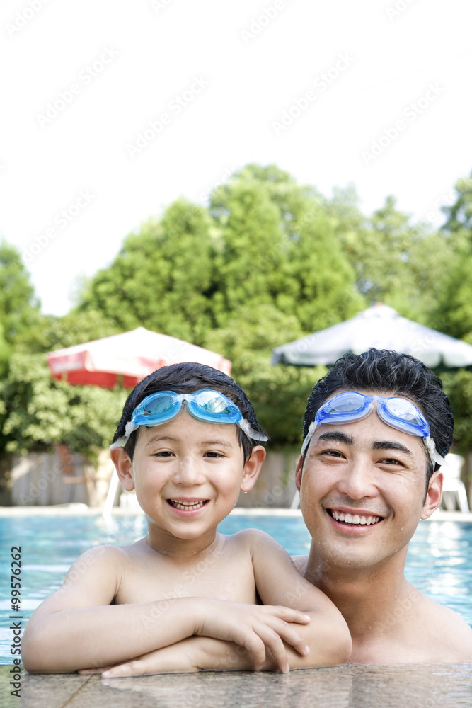父亲和女儿在游泳池游泳