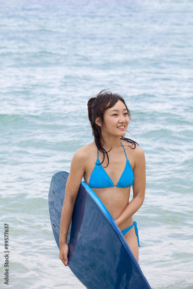 一个拿着冲浪板的年轻女子的肖像