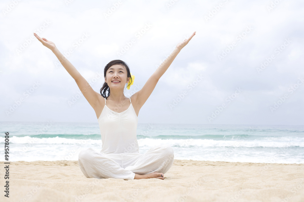 一个女人在海滩上练习瑜伽