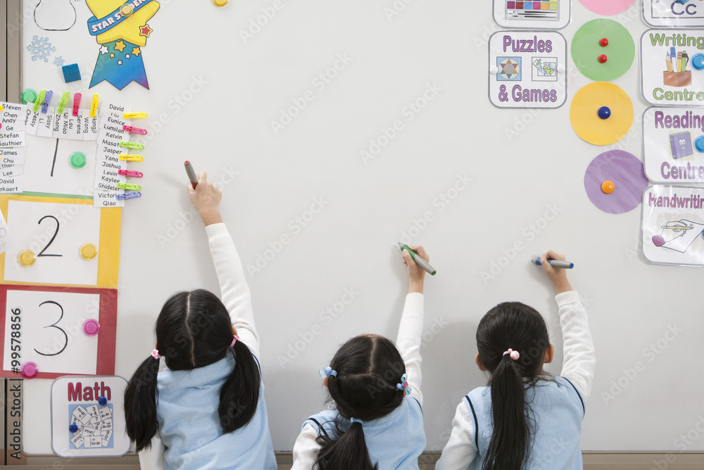 三个学生一起在白板上写字