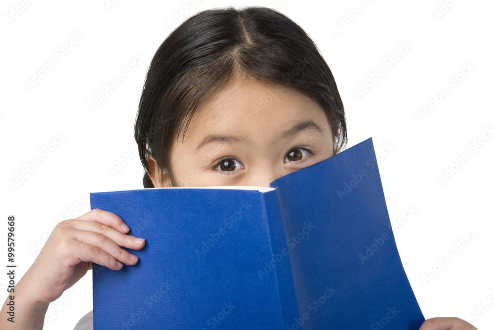 小女孩用书遮住脸