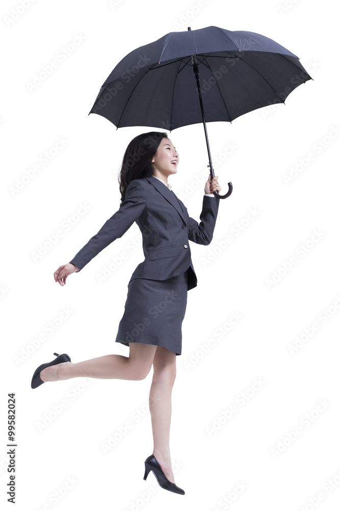 Businesswoman jumping with umbrella in hand