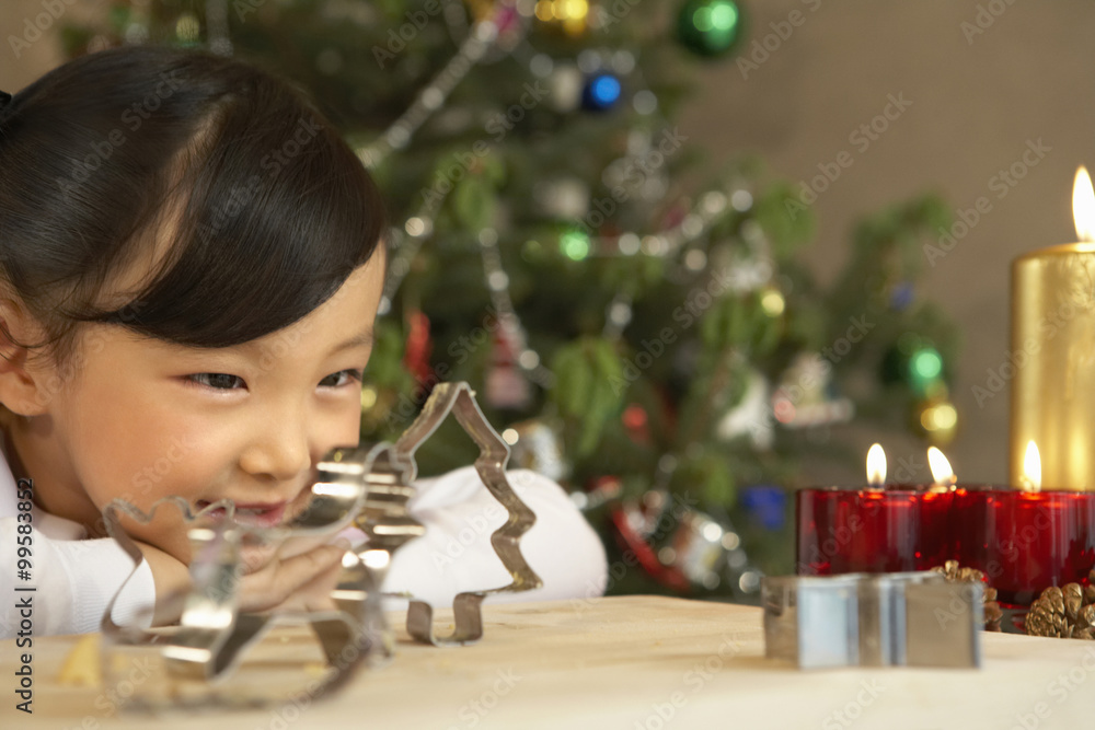 女孩看着圣诞树饼干切割器