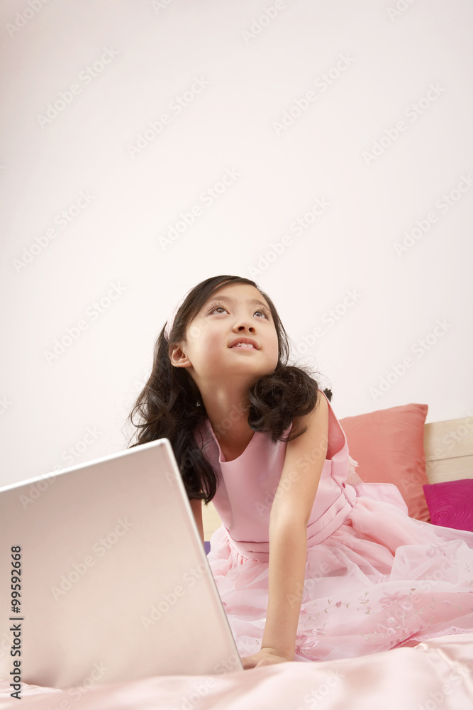 女孩坐在床上用笔记本电脑