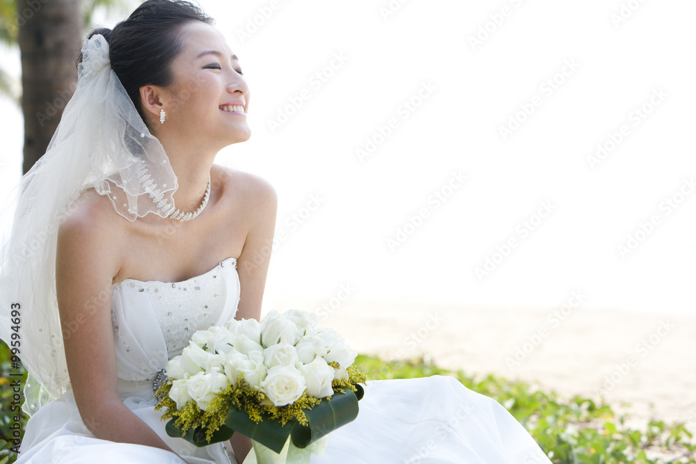 快乐的新娘坐在海滩上