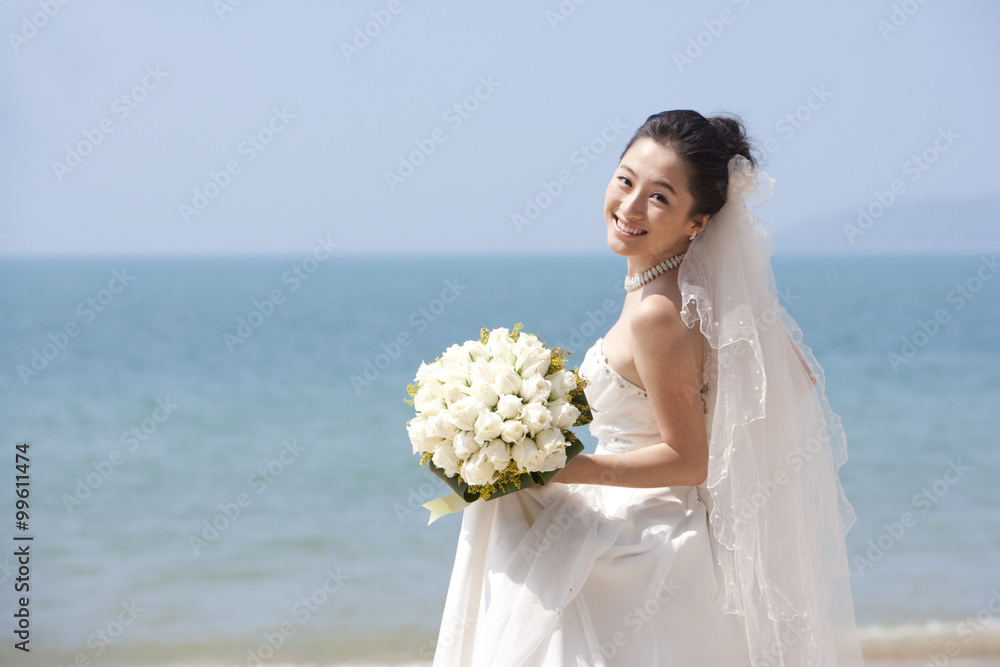 新娘在海滩上散步时回头看