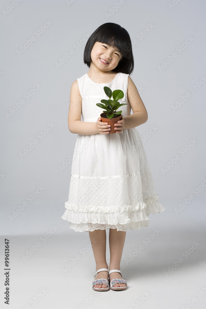 Little girl holding a plant